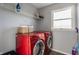 Cozy laundry room with a window, red washer and dryer, and storage shelves at 8415 Anchorage Ct, Indianapolis, IN 46236