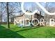 Exterior backyard featuring a blue deck, lush green grass, and mature trees at 8500 N Ravenwood Dr, Muncie, IN 47303