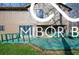 Back exterior showcasing a tan siding with grey brick base, and a blue deck with green trim at 8500 N Ravenwood Dr, Muncie, IN 47303