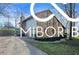 Beautiful home with a stone and siding exterior, a well-maintained driveway, and lovely landscaping at 8500 N Ravenwood Dr, Muncie, IN 47303