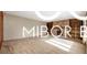 Spacious living room features stylish hardwood flooring, neutral paint, and a decorative stone fireplace at 8500 N Ravenwood Dr, Muncie, IN 47303