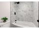 Elegant bathroom with white marble-like tile, black fixtures, and a shower-tub combination at 8695 Shoe Overlook Dr, Fishers, IN 46038