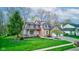 Charming two-story home with brick facade, covered porch, manicured lawn, and attached two-car garage at 8695 Shoe Overlook Dr, Fishers, IN 46038