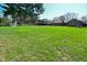 A spacious backyard featuring lush green grass, mature trees, and a residence in the background at 8808 Rocky Hill Rd, Indianapolis, IN 46217