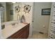 Stylish bathroom featuring wood cabinets, a white countertop, and nautical decor at 8808 Rocky Hill Rd, Indianapolis, IN 46217