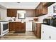 Kitchen featuring wood cabinetry, white appliances, and durable wood-look flooring at 8808 Rocky Hill Rd, Indianapolis, IN 46217