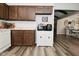Functional kitchen featuring wood cabinets, white appliances, and wood-look flooring at 8808 Rocky Hill Rd, Indianapolis, IN 46217