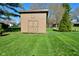 A backyard shed with wooden doors is situated on a well maintained lawn at 8808 Rocky Hill Rd, Indianapolis, IN 46217