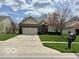 Charming single-story home featuring a well-manicured lawn, two-car garage, and inviting facade at 8875 Stonewick Way, Zionsville, IN 46077
