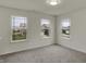 Bright bedroom with plush carpeting and ample natural light from a triple window setup overlooking the neighborhood at 8961 Fitzgerald Dr, Indianapolis, IN 46239