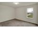 Well-lit bedroom with neutral carpeting and a large window offering neighborhood views at 8961 Fitzgerald Dr, Indianapolis, IN 46239