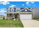 Inviting two-story home with a brick facade, attached garage, and well-manicured lawn at 8961 Fitzgerald Dr, Indianapolis, IN 46239