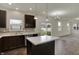The kitchen features an island, stainless steel appliances, dark cabinetry, and overlooks the living area and yard at 8961 Fitzgerald Dr, Indianapolis, IN 46239