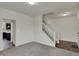 Bright living room area featuring a staircase and a glimpse of a kitchen space at 8961 Fitzgerald Dr, Indianapolis, IN 46239