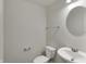 This powder room offers a pedestal sink, updated fixtures, and round mirror, perfect for guests and everyday use at 8961 Fitzgerald Dr, Indianapolis, IN 46239