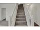 Carpeted staircase with white railings, leading to the upper level, ensuring a safe and stylish transition at 8961 Fitzgerald Dr, Indianapolis, IN 46239