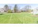 Large backyard featuring a well-manicured lawn, mature trees, and a swing set at 918 N 700 W, Greenfield, IN 46140