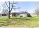 Well-maintained home featuring a stone exterior, lush lawn, and mature trees at 918 N 700 W, Greenfield, IN 46140