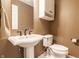 Bathroom showcasing a pedestal sink, a mirror, toilet, and a towel rack at 9609 Highgate N Cir, Indianapolis, IN 46250