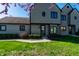 Inviting townhouse showcasing a unique round window, well-kept lawn, and vibrant flowering tree, enhancing its curb appeal at 9609 Highgate N Cir, Indianapolis, IN 46250