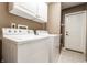 Laundry room featuring white cabinets, a washer, dryer and a door at 9609 Highgate N Cir, Indianapolis, IN 46250
