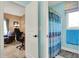 Bathroom showcasing a shower with a blue patterned curtain and an adjacent office space at 9879 Ruby Ct, Mooresville, IN 46158