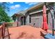 View of a brick home and outdoor living space that features a spacious wooden deck with a vibrant red umbrella at 9879 Ruby Ct, Mooresville, IN 46158