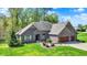 Charming brick home with a well-manicured lawn, beautiful landscaping, and a spacious three-car garage at 9879 Ruby Ct, Mooresville, IN 46158
