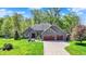 Beautiful brick home featuring a three-car garage and a well-manicured lawn at 9879 Ruby Ct, Mooresville, IN 46158