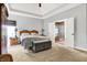Spacious main bedroom featuring a tray ceiling, carpet floors, and ensuite bathroom entrance at 9879 Ruby Ct, Mooresville, IN 46158