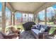 Relaxing screened-in porch with comfortable wicker furniture, a grill, and views of the landscaped backyard at 10518 Greenway Dr, Fishers, IN 46037