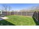 Spacious backyard featuring lush green grass and a tall privacy fence, fire pit, and patio area at 10876 Bellflower Ct, Indianapolis, IN 46235