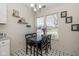 Cozy dining area with a black table and chairs, illuminated by natural light from nearby windows at 10876 Bellflower Ct, Indianapolis, IN 46235
