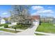 Well-maintained single Gathering home with green lawn, mature flowering tree, and brick facade garage at 10876 Bellflower Ct, Indianapolis, IN 46235