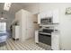 Modern kitchen with stainless steel appliances, white cabinetry, and black and white tiled flooring at 10876 Bellflower Ct, Indianapolis, IN 46235