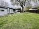 Large grassy backyard with a covered patio and wooden fence at 122 Southlane Dr, New Whiteland, IN 46184