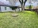 Large, grassy backyard with a fire pit and wooden fence, perfect for outdoor entertaining at 122 Southlane Dr, New Whiteland, IN 46184