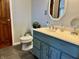 Bathroom features a painted blue vanity, framed mirror, and neutral tile flooring at 122 Southlane Dr, New Whiteland, IN 46184