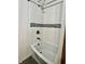 A close up of a bright bathtub with a tiled wall and black and white accent tiles at 122 Southlane Dr, New Whiteland, IN 46184