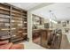 Basement bar with dark wood cabinets, a bookshelf, counter seating, pendant lighting, and hardwood floors at 12223 Split Granite Dr, Fishers, IN 46037