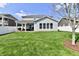 Expansive backyard with a covered patio, lush green lawn, and pristine white fencing at 1291 Timber Bluff Rd, Westfield, IN 46074