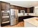 A kitchen boasts stainless steel appliances, dark wood cabinetry, granite countertops, and hardwood flooring at 1291 Timber Bluff Rd, Westfield, IN 46074