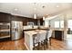 Modern kitchen featuring stainless steel appliances, granite countertops, dark wood cabinets, and a center island with seating at 1291 Timber Bluff Rd, Westfield, IN 46074
