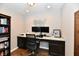 Home office with dark wood cabinets, dual monitors, hardwood flooring, and a modern desk setup at 1291 Timber Bluff Rd, Westfield, IN 46074