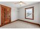 Bedroom with neutral carpet, wooden trim, door and window at 1417 Sturm Ave, Indianapolis, IN 46201