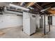 Unfinished basement space featuring a refrigerator, white painted walls, and exposed ductwork at 1417 Sturm Ave, Indianapolis, IN 46201