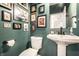 Small bathroom features pedestal sink, toilet, and framed prints and photos on dark green walls at 1603 E Market St, Indianapolis, IN 46201