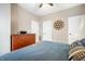 Bedroom with wood floors, ceiling fan, decorative wall hanging, large dresser and king bed with blue bedding at 1603 E Market St, Indianapolis, IN 46201