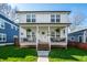 Charming two-story home with a inviting front porch, fresh green lawn, and beautiful curb appeal at 1603 E Market St, Indianapolis, IN 46201