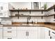 Bright kitchen with stainless steel sink, wooden countertops, open shelving, and white appliances at 1603 E Market St, Indianapolis, IN 46201